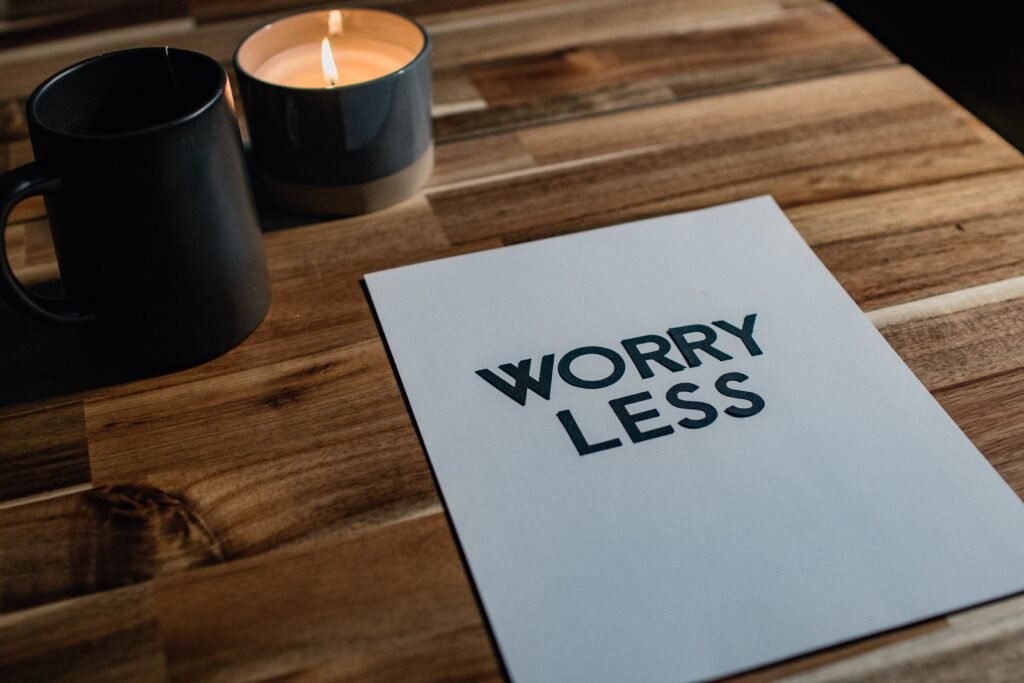 Inspirierendes Bild mit der Botschaft 'WORRY LESS' neben einer Kerze